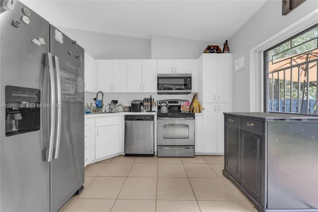 a kitchen with a refrigerator sink and cabinets