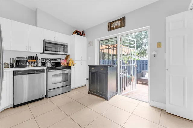 a kitchen with white cabinets and white appliances