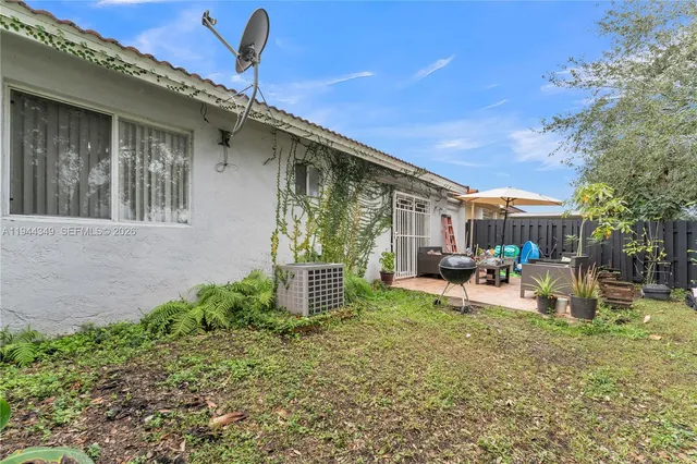 a view of a house with backyard and sitting area
