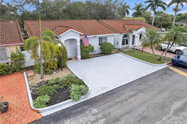 an aerial view of a house with a yard and potted plants