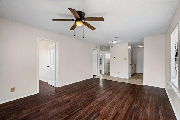 a view of an empty room with wooden floor