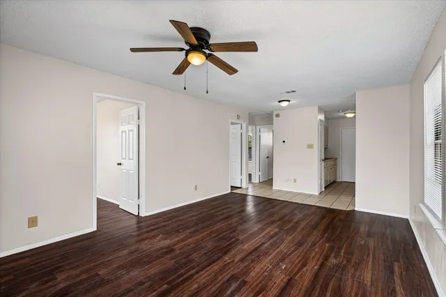 a view of an empty room with wooden floor