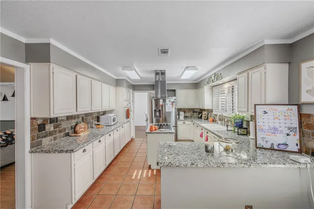 a kitchen with stainless steel appliances granite countertop a sink and a refrigerator