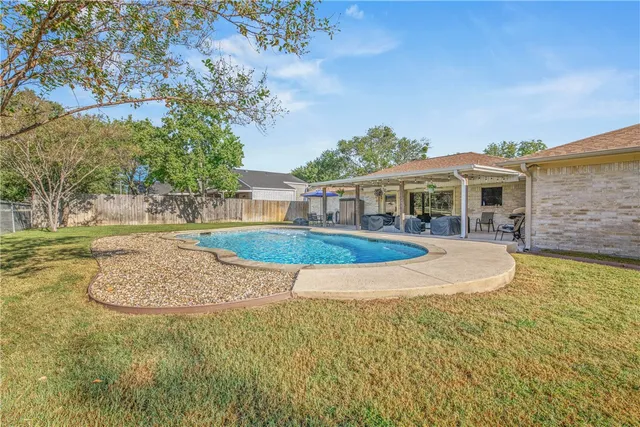 an aerial view of a house with a yard and a large tree