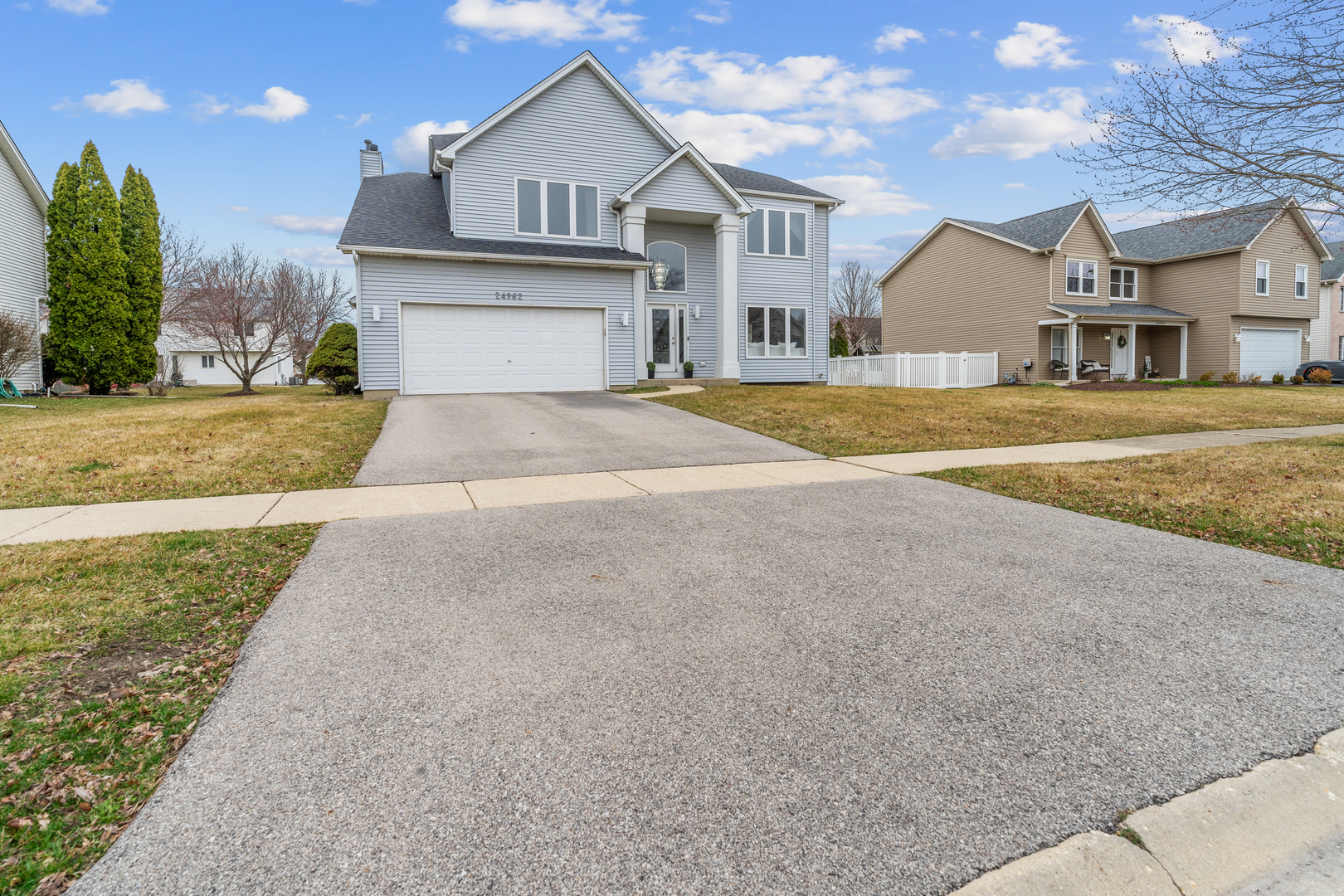 24962 Ambrose Road Plainfield, IL 60585 - Photo 2 of 28 a view of a white house with a yard next to a road