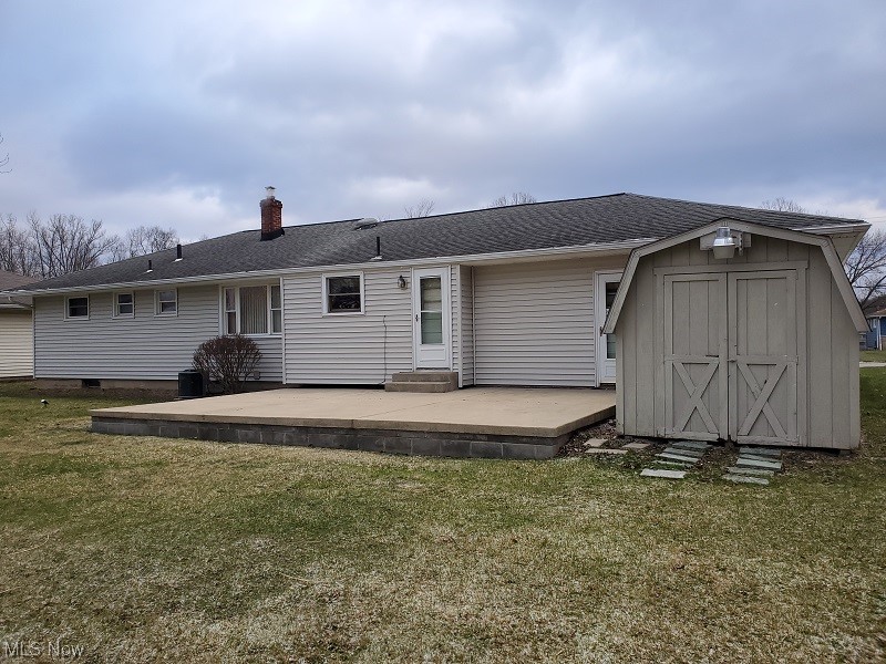 932 Pinecrest Road Girard, OH 44420 - Photo 3 of 25 Back of house with a storage unit and a lawn