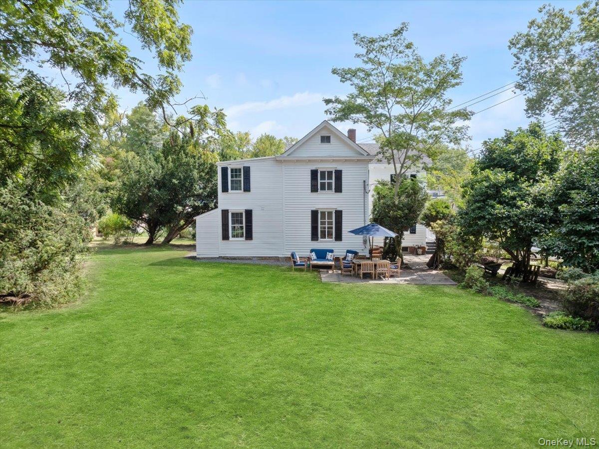Back of house with a patio area, a lawn, a chimney, and outdoor lounge area