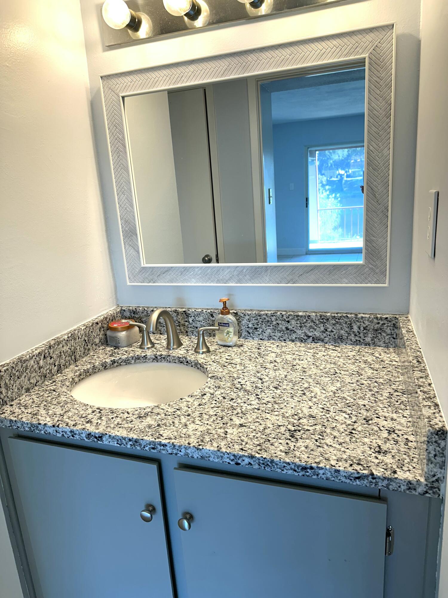 210 Pelham Road, Unit 208C Fort Walton Beach, FL 32547 - Photo 11 of 13 a bathroom with a granite countertop sink and a mirror