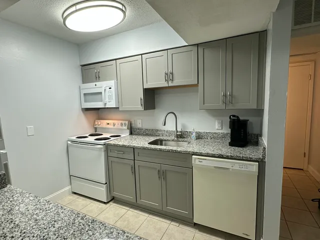 a kitchen with stainless steel appliances granite countertop a sink stove and cabinets