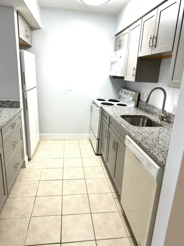 a kitchen with a sink a stove top oven and a counter top space
