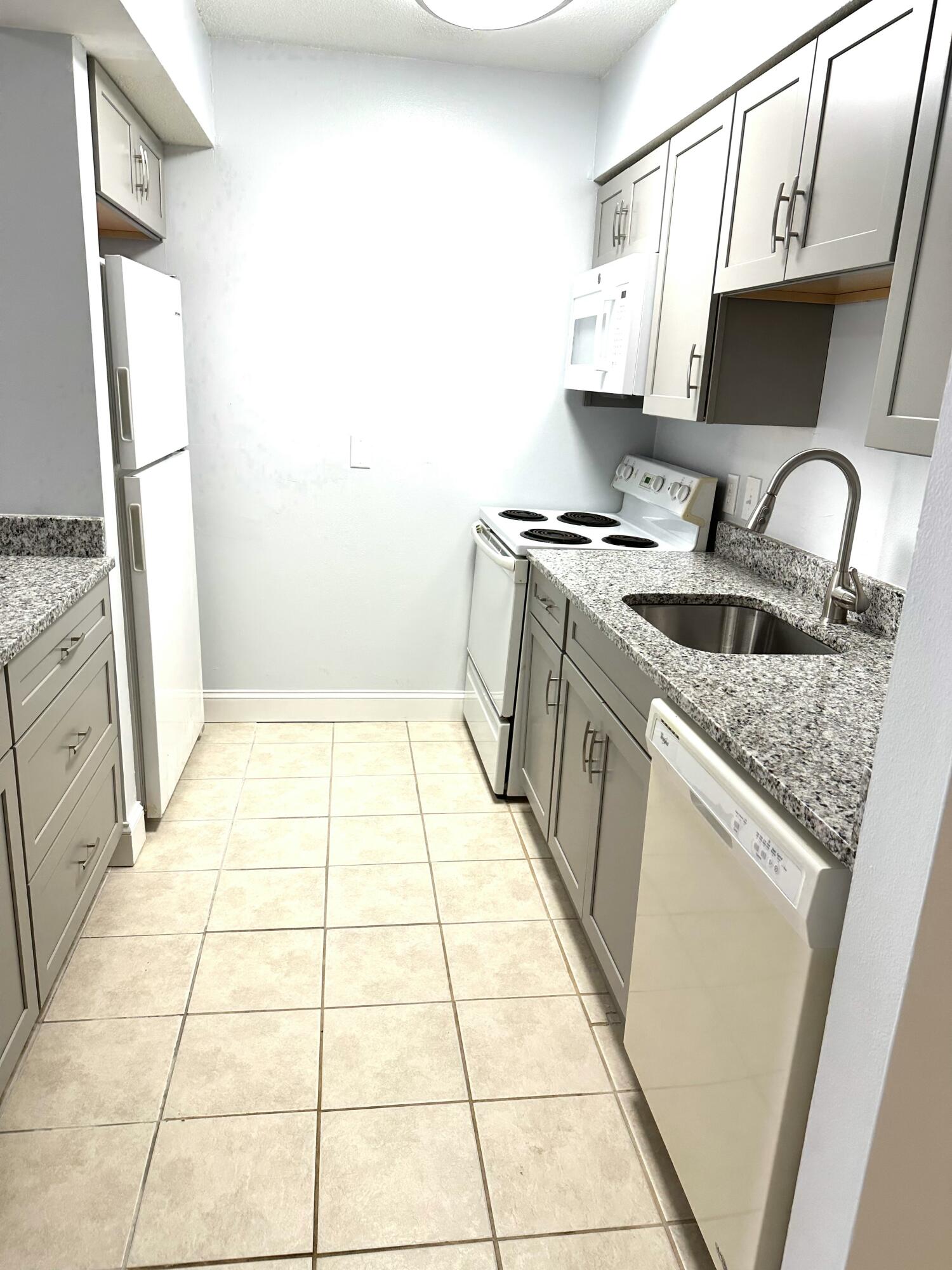 210 Pelham Road, Unit 208C Fort Walton Beach, FL 32547 - Photo 6 of 13 a kitchen with a sink a stove top oven and a counter top space