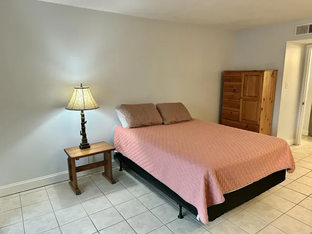 a bedroom with a bed and a lamp