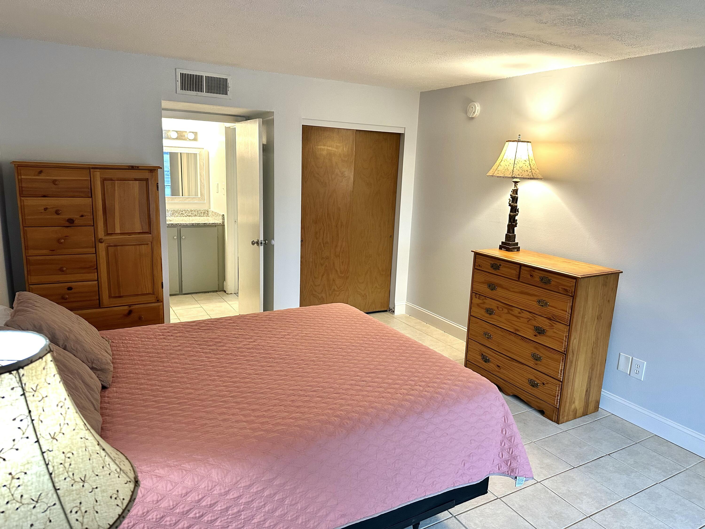 210 Pelham Road, Unit 208C Fort Walton Beach, FL 32547 - Photo 8 of 13 a bedroom with a bed and a dresser