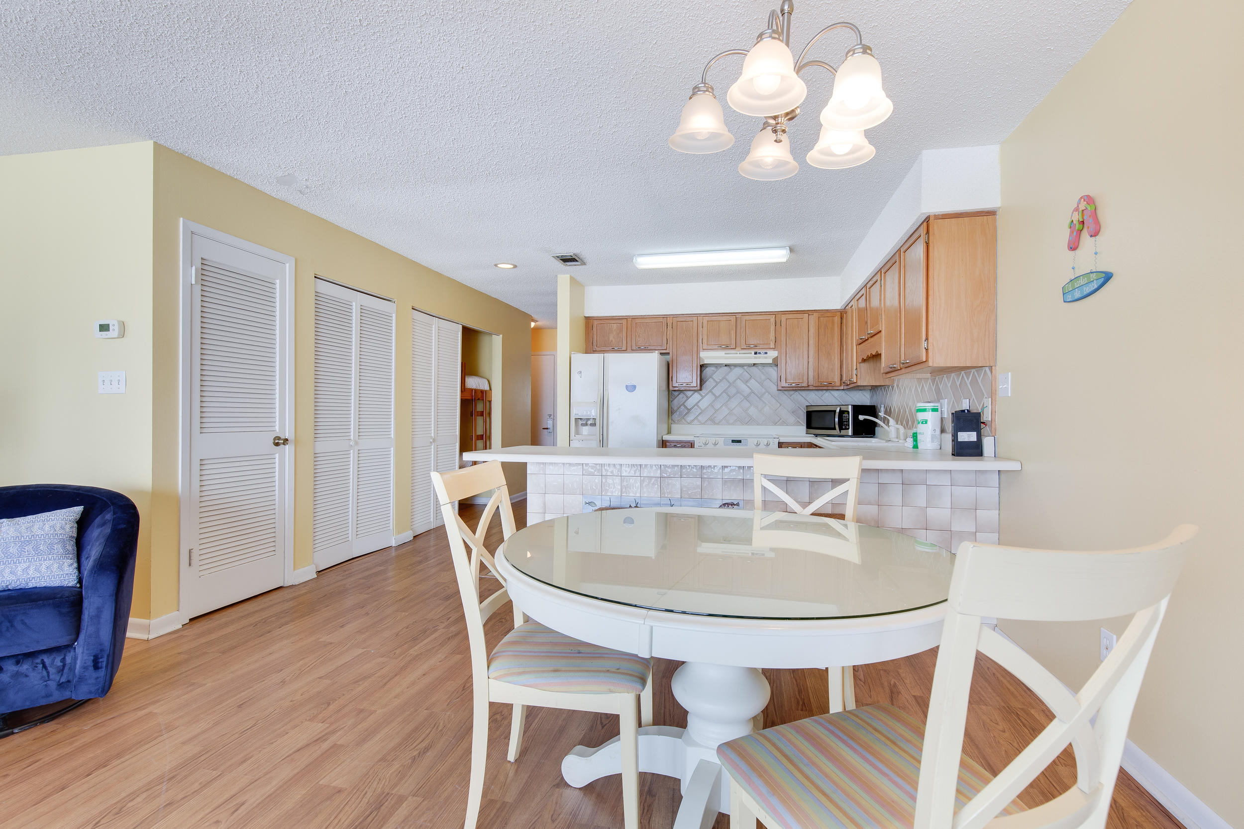 214 Blue Mountain Road, Unit 124 Santa Rosa Beach, FL 32459 - Photo 11 of 30 a dining room with wooden floor a chandelier a wooden table and chairs