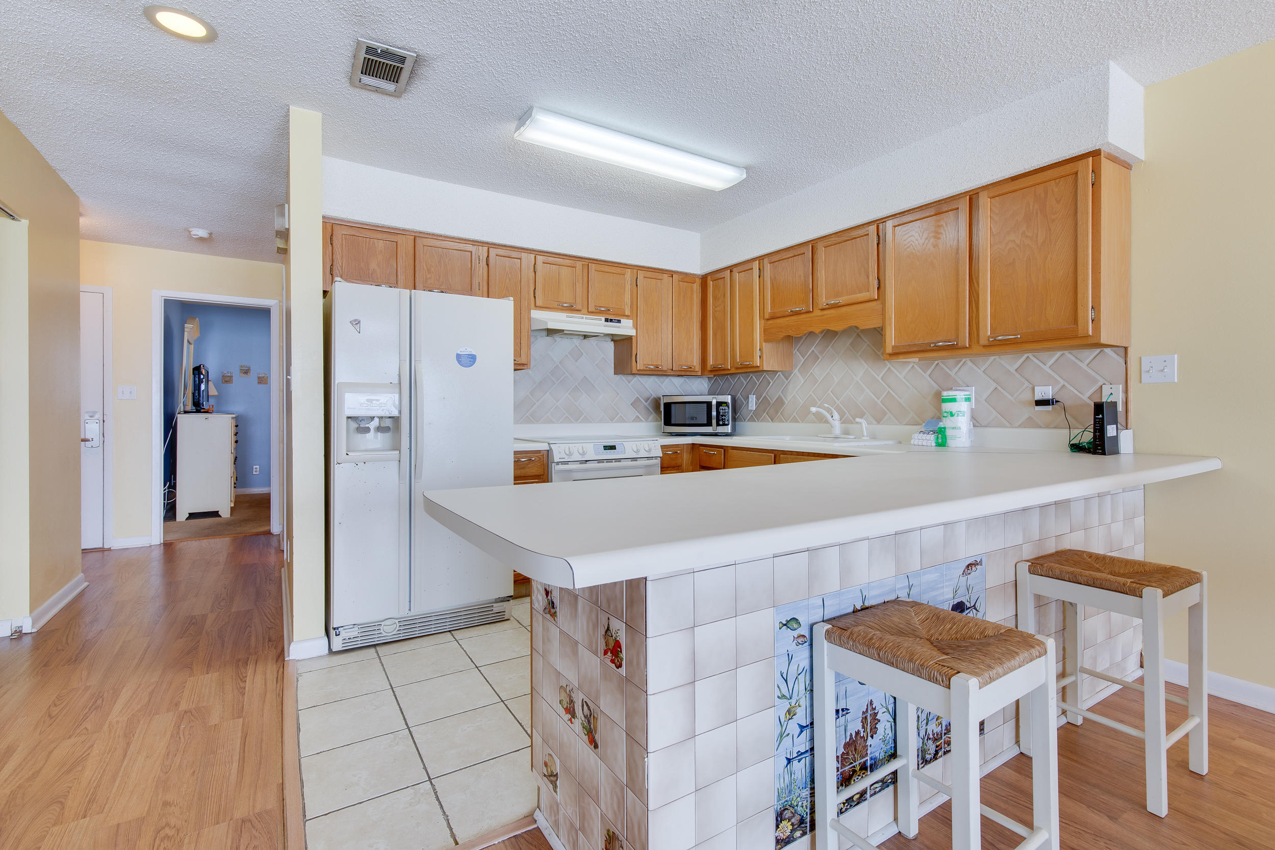 214 Blue Mountain Road, Unit 124 Santa Rosa Beach, FL 32459 - Photo 14 of 30 a kitchen with a sink a refrigerator and chairs