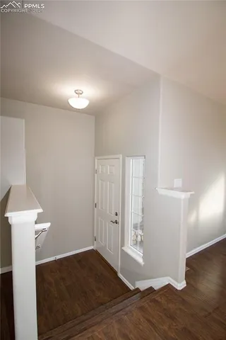 a view of empty room with wooden floor