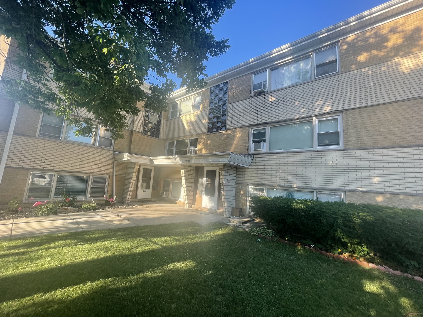 6022 West Fullerton Avenue, Unit 7BN Chicago, IL 60639 - Photo 1 of 12 a front view of a house with a yard