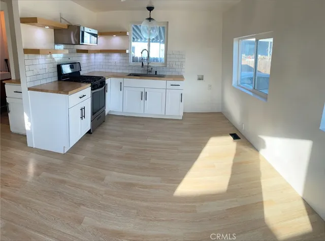 a kitchen with stainless steel appliances granite countertop a sink stove and cabinets