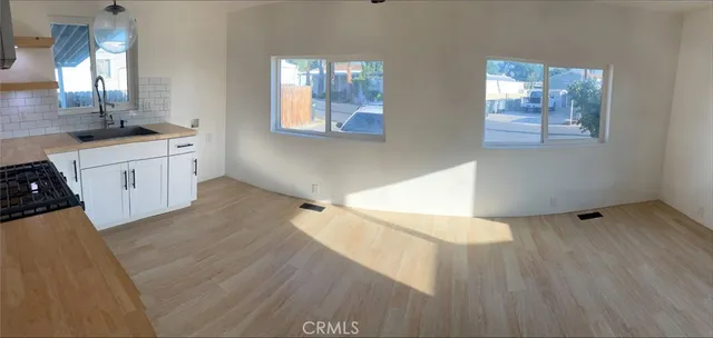 a view of a kitchen with wooden floor and electronic appliances