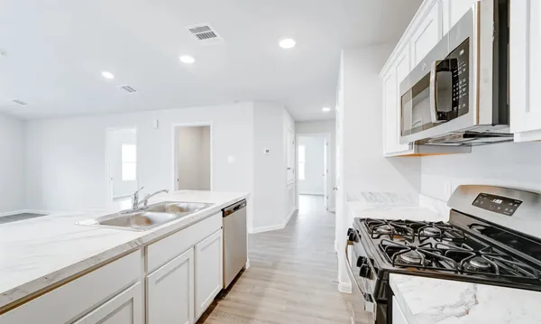 a kitchen with sink stove and cabinets