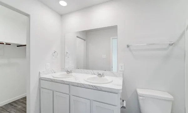 a bathroom with a granite countertop sink a toilet and a mirror