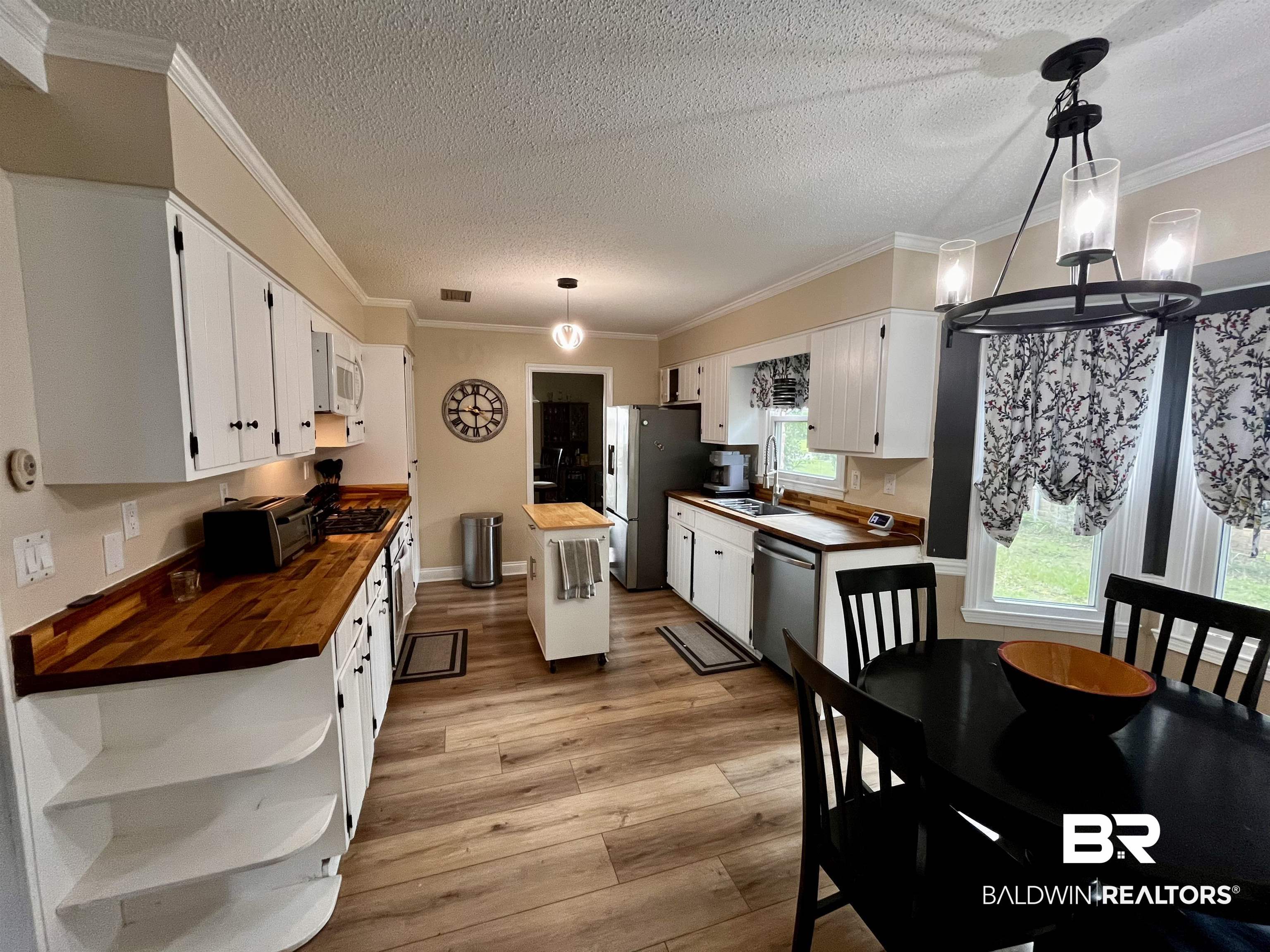 6429 Pinehurst Run Mobile, AL 36608 - Photo 2 of 15 Kitchen featuring wood-finish flooring, white cabinetry, wood countertops, and a dining area with a contemporary chandelier