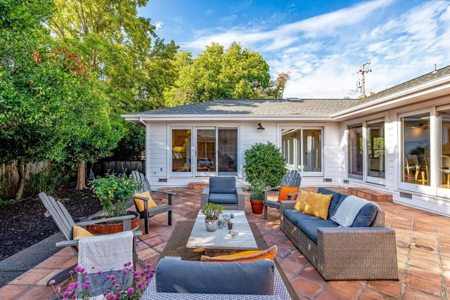 a view of a patio with couches table and chairs and potted plants