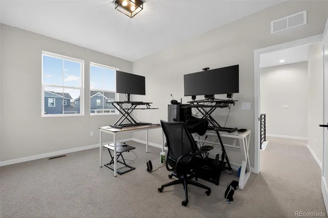 a view of a workspace with furniture and a window