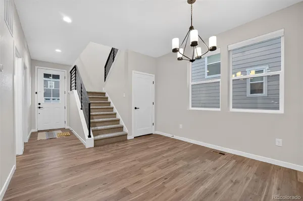 a view of empty room with wooden floor and window