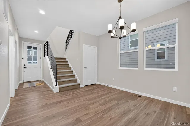 a view of empty room with wooden floor and window
