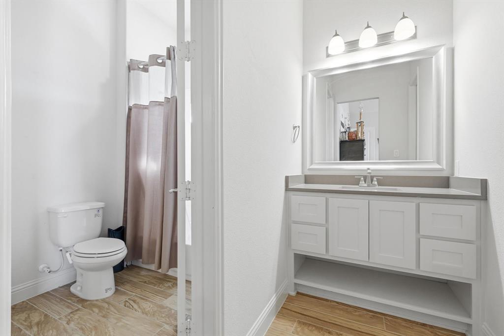 7751 Faught Road Northlake, TX 76226 - Photo 26 of 39 Bathroom featuring a white vanity with a gray countertop, an undermount sink, and a framed mirror