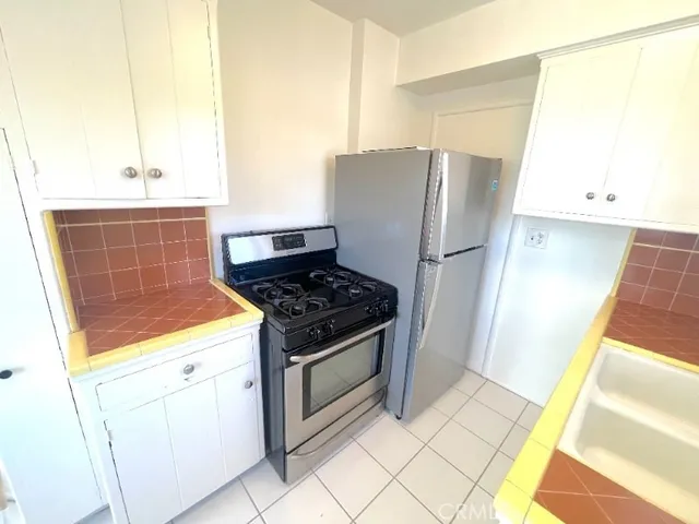 a kitchen with refrigerator and cabinets