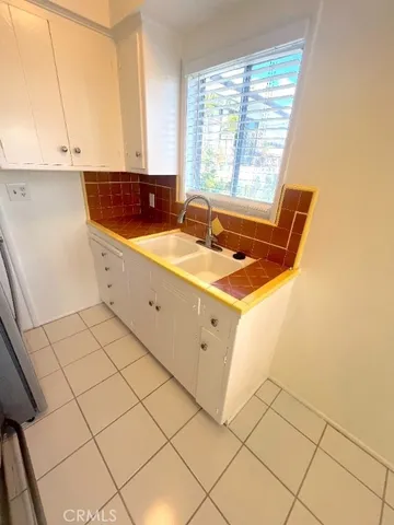 a view of a kitchen with stainless steel appliances cabinets a sink and a window