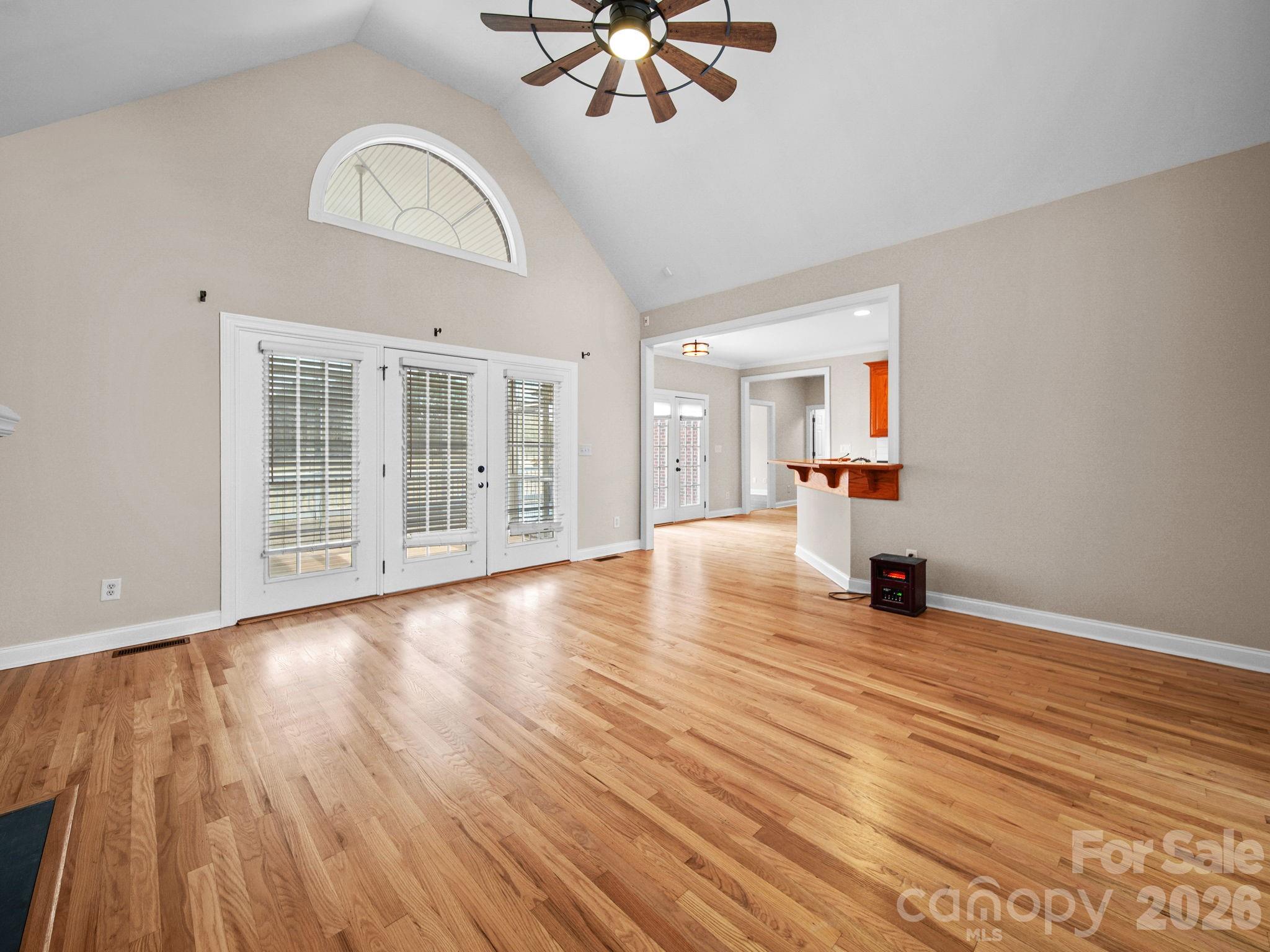 715 Witmore Road Wingate, NC 28174 - Photo 11 of 48 an empty room with wooden floor chandelier fan and windows