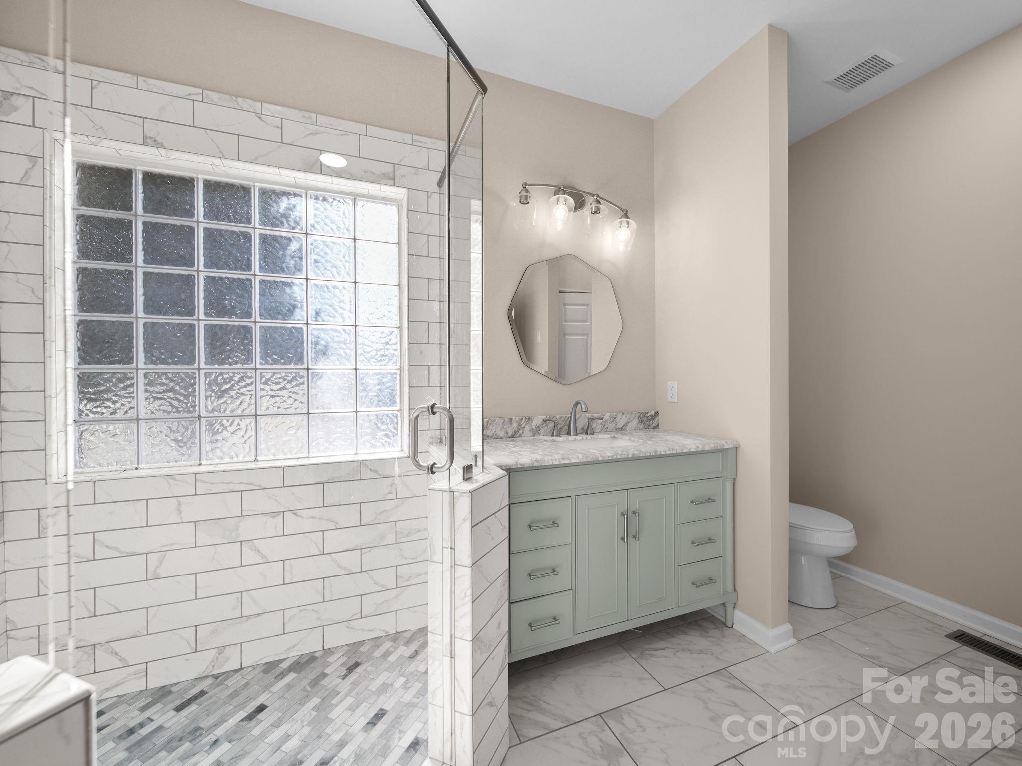 715 Witmore Road Wingate, NC 28174 - Photo 22 of 48 a bathroom with a granite countertop toilet a sink and a mirror