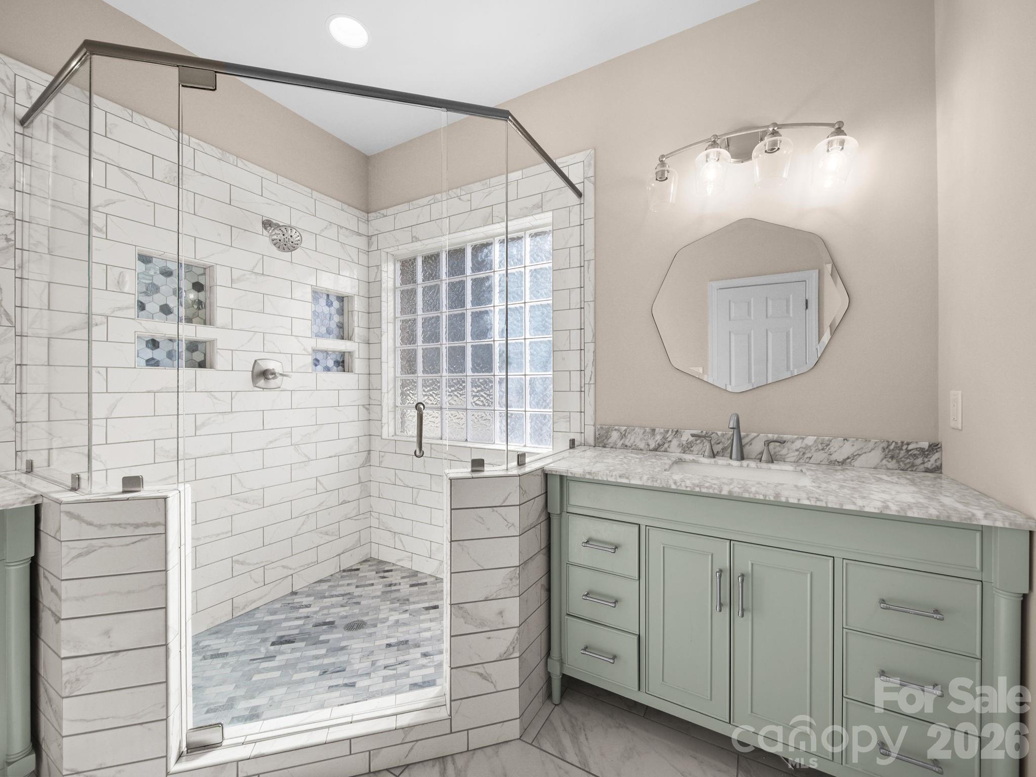 715 Witmore Road Wingate, NC 28174 - Photo 23 of 48 a bathroom with a granite countertop sink a mirror a vanity and a shower