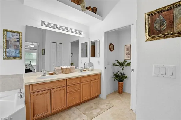 a spacious en suite bathroom with a granite countertop sink and a mirror