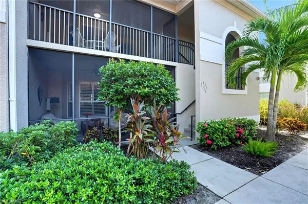 a view of a house with a small yard and flower plants