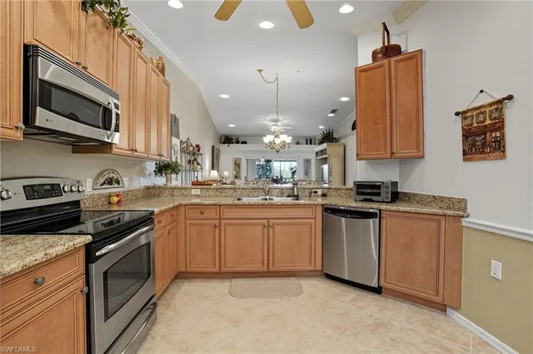 a kitchen with stainless steel appliances granite countertop a sink a stove and a microwave