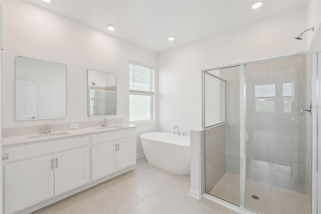 1672 Rider Rain Lane Apopka, FL 32703 - Photo 24 of 35 a bathroom with a double vanity sink mirror and shower