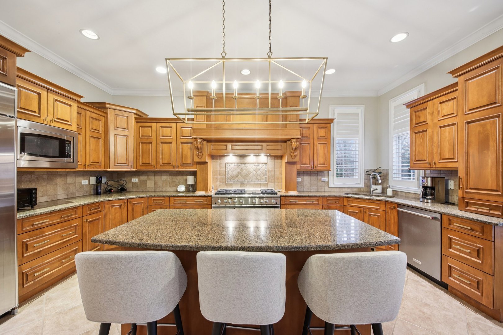 1135 North Main Street Naperville, IL 60563 - Photo 12 of 52 a kitchen with stainless steel appliances granite countertop a kitchen island a stove a table and chairs in it