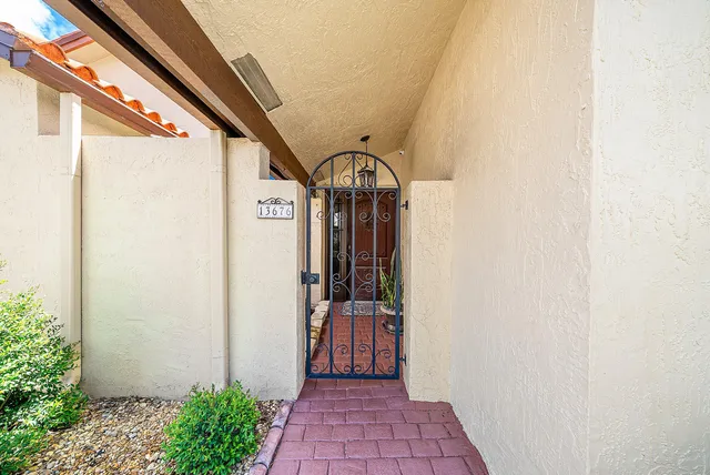 a kitchen with stainless steel appliances kitchen island granite countertop a dining table chairs and a refrigerator