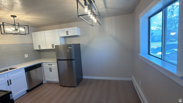 647 Swenson Avenue, Unit 4 Springville, UT 84663 - Photo 3 of 14 Kitchen with stainless steel appliances, white cabinetry, a baseboard radiator, dark wood-style floors, and a textured ceiling