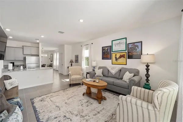 a living room with furniture and view of kitchen