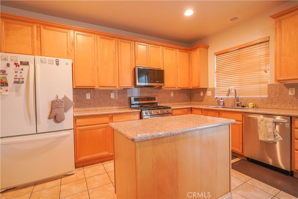 15133 Pasture Way Victorville, CA 92394 - Photo 16 of 48 a kitchen with stainless steel appliances a refrigerator sink and cabinets