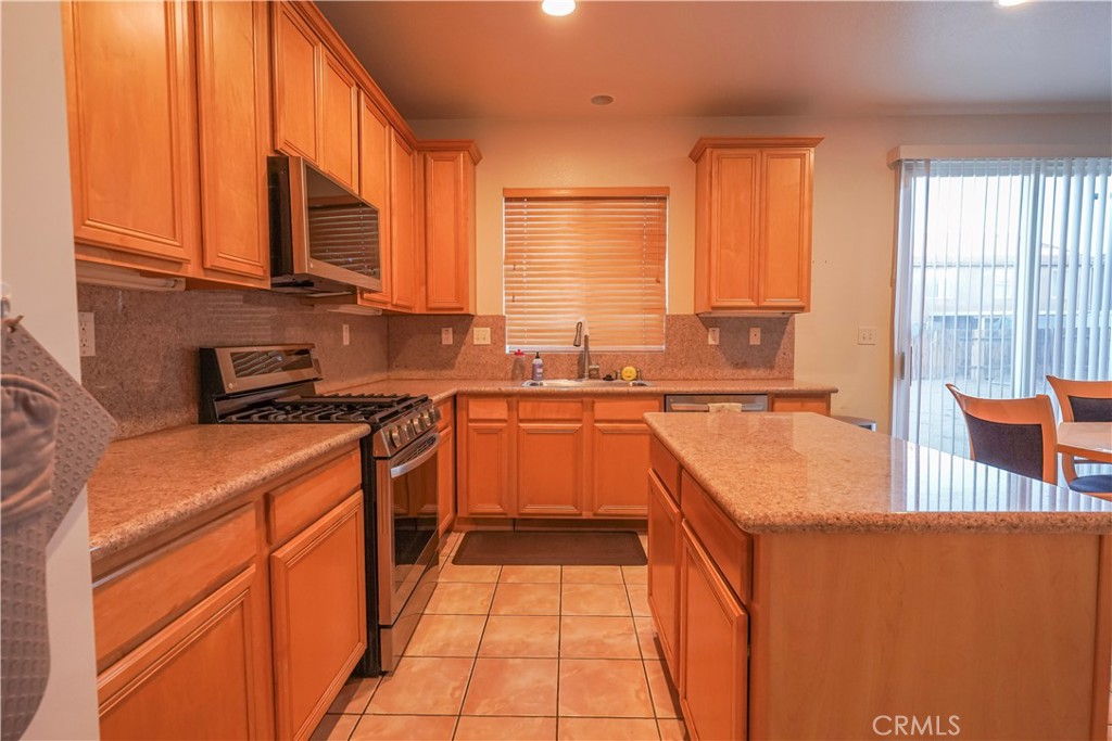 15133 Pasture Way Victorville, CA 92394 - Photo 19 of 48 a kitchen with stainless steel appliances granite countertop a stove a sink and a microwave