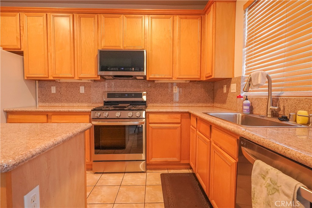 15133 Pasture Way Victorville, CA 92394 - Photo 21 of 48 a kitchen with stainless steel appliances a stove sink and cabinets