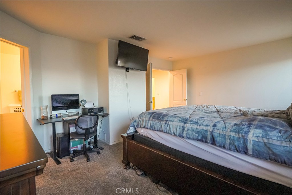 15133 Pasture Way Victorville, CA 92394 - Photo 38 of 48 a bedroom with a bed and a computer on a desk next to a window