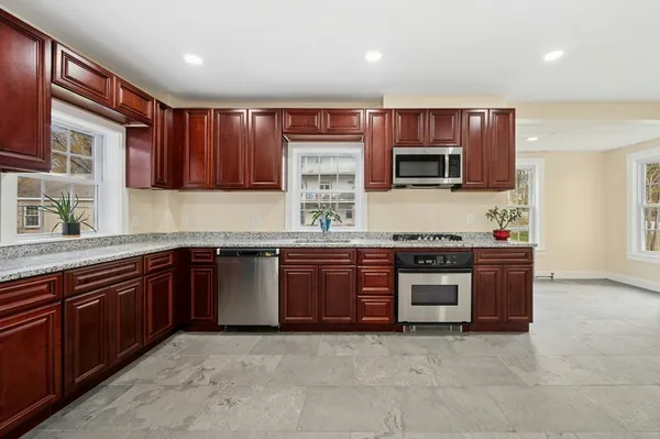 a kitchen with stainless steel appliances granite countertop a stove microwave and sink