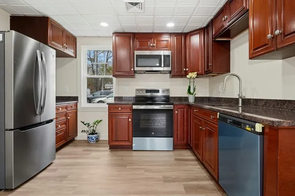 a large kitchen with stainless steel appliances granite countertop a stove and a sink